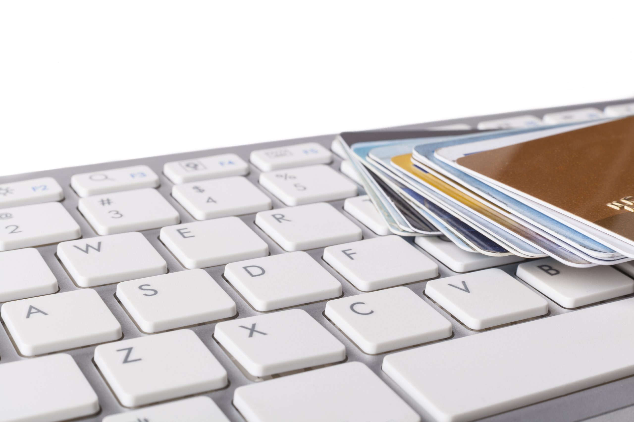 Multiple,credit,cards,on,computer,keyboard,on,white,background